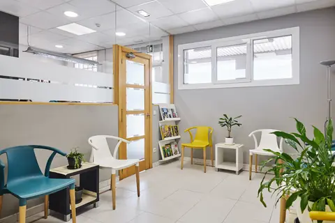Hortzagin Klinikako itxarongela argitsua, eserlekuekin eta landareekin.